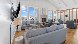 Un salón amplio con chimenea, ventanas grandes y un diseño moderno.