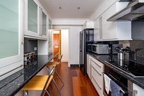 Apartamento Confort | Cocina privada | Frigorífico grande, microondas, horno y placa de cocina