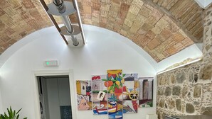 Una habitación de hotel con cama, sofá, zona de comedor y pared de piedra.