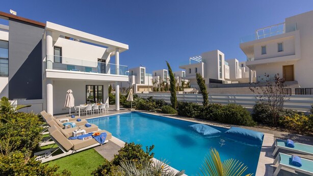 A modern resort with a swimming pool, lounge chairs, and a well-maintained garden. - stunning and luxurious villa is located in the popular resort area of Protaras (Protaras)