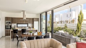 A modern apartment with a kitchen, dining area, and a large balcony with plants. - stunning and luxurious villa is located in the popular resort area of Protaras (Protaras)