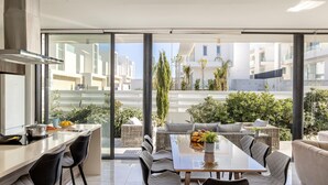 A modern kitchen with a dining area, large windows, and a view of the cityscape. - stunning and luxurious villa is located in the popular resort area of Protaras (Protaras)
