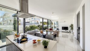 A modern kitchen with a large island, dining area with a TV, and a view of the city. - stunning and luxurious villa is located in the popular resort area of Protaras (Protaras)