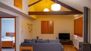 Ein gemütliches Wohnzimmer mit Sofa, Fernseher und Kamin.