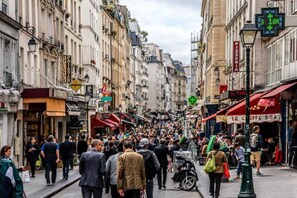 Eine belebte Innenstadtstraße mit Fußgängern und Geschäften.