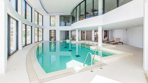A modern indoor swimming pool with a clear view of the surrounding architecture, including large windows and a multi-level design. - RDR304 - Stunning 2 bedroom Palo Alto, pool, gym + more! (Marbella)