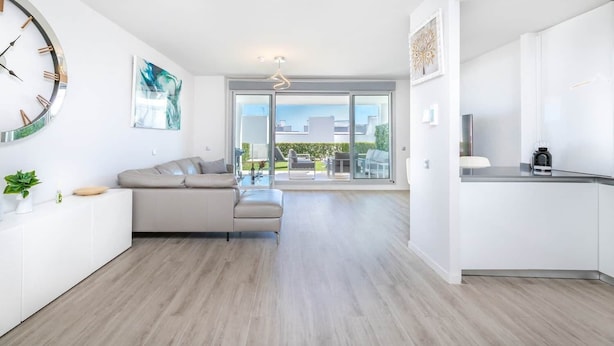 Een modern appartement met een woonruimte, keuken en balkon met uitzicht op de stad.