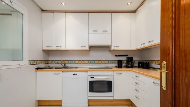 A compact kitchen with white cabinets, a dishwasher, an oven, and a coffee maker. - RDR372 - Beach Charm apartment Costalita (Estepona)