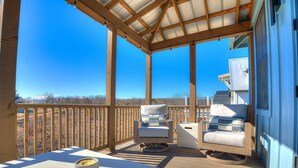 Una terrazza esterna coperta con mobili in legno e vista sul paesaggio.