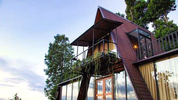 A modern house with large glass windows, a balcony, and a view of the landscape. - The Backyard Blangoda (Balangoda)