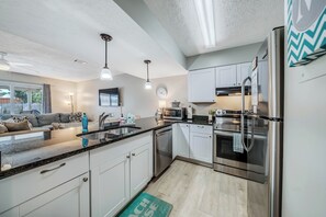 A modern kitchen with stainless steel appliances, a built-in oven, and a microwave.