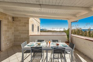 A covered outdoor dining area with a table set for four, overlooking a scenic view. - 3758 Villetta Elenia By Barbarhouse (Manduria)