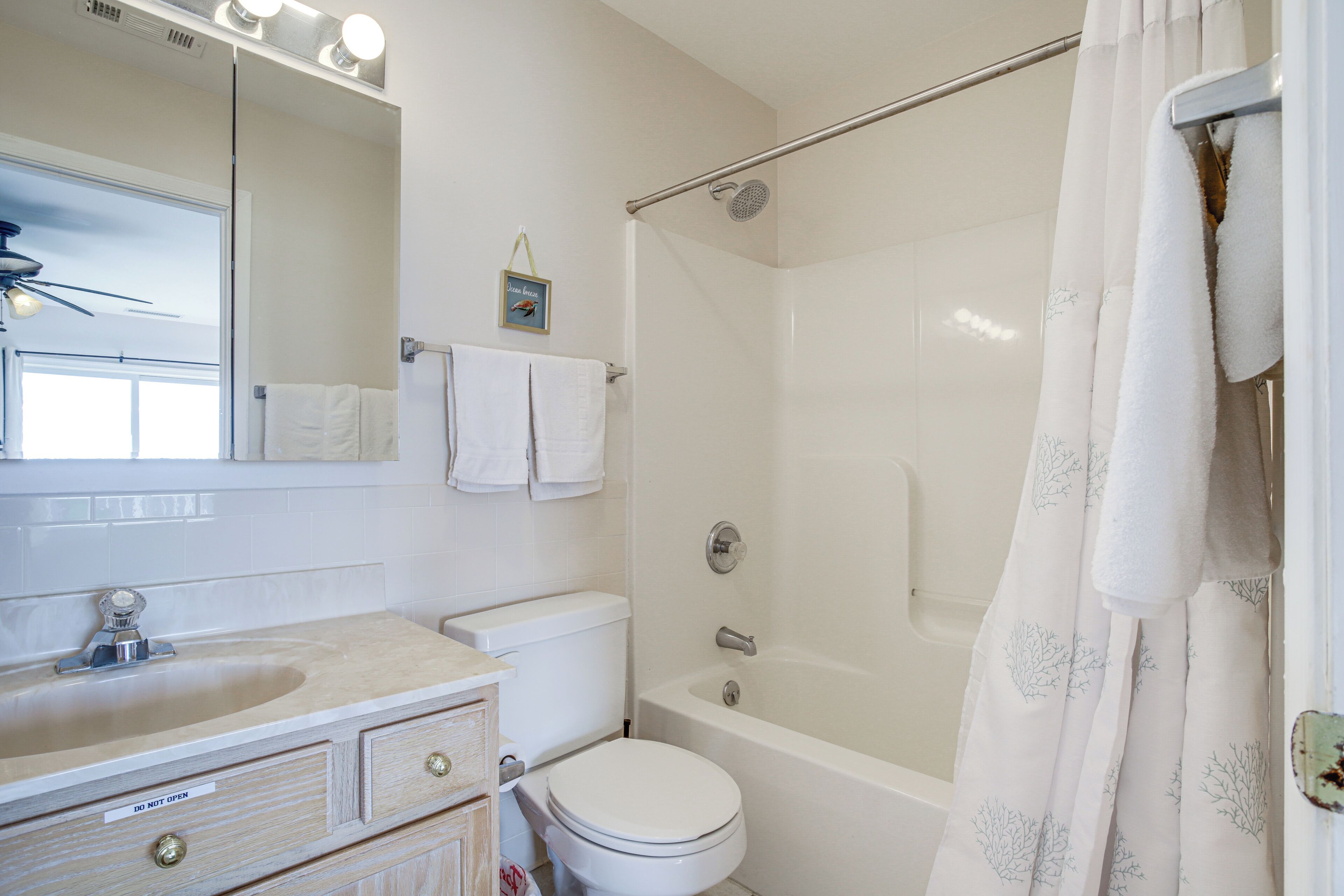 Een badkamer met toilet, wastafel en bad.