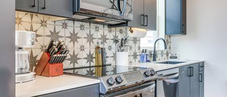 A modern kitchen with a built-in oven, microwave, and stainless steel cabinets.