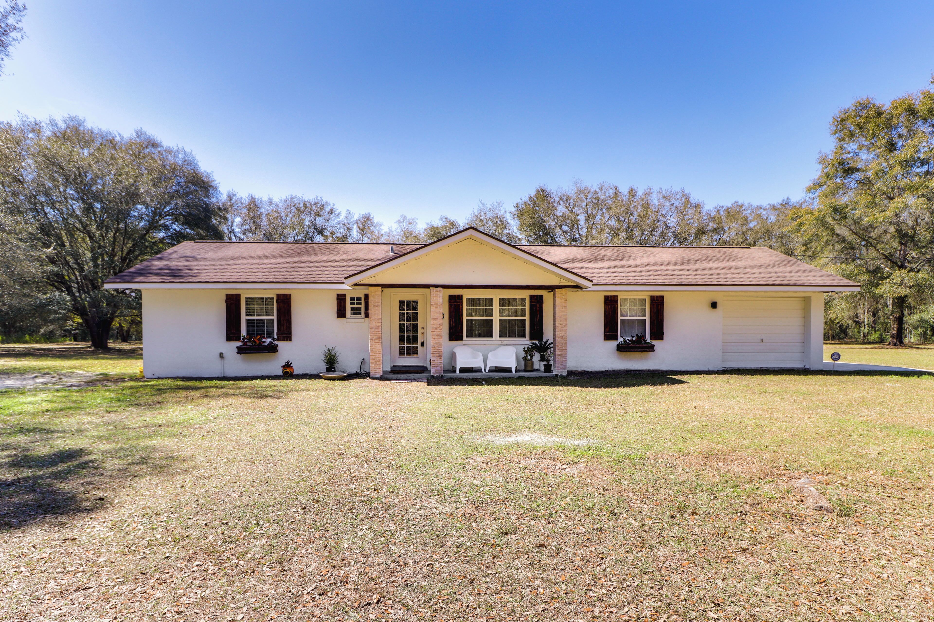 A single-story house with a front porch, a garage, and a well-maintained lawn.