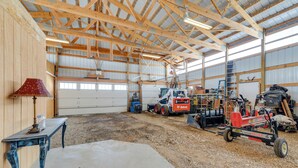 A spacious industrial interior with high ceilings, exposed wooden beams, and a concrete floor. - Thayne Retreat w/ Mountain Views - Near Trails! (Thayne)