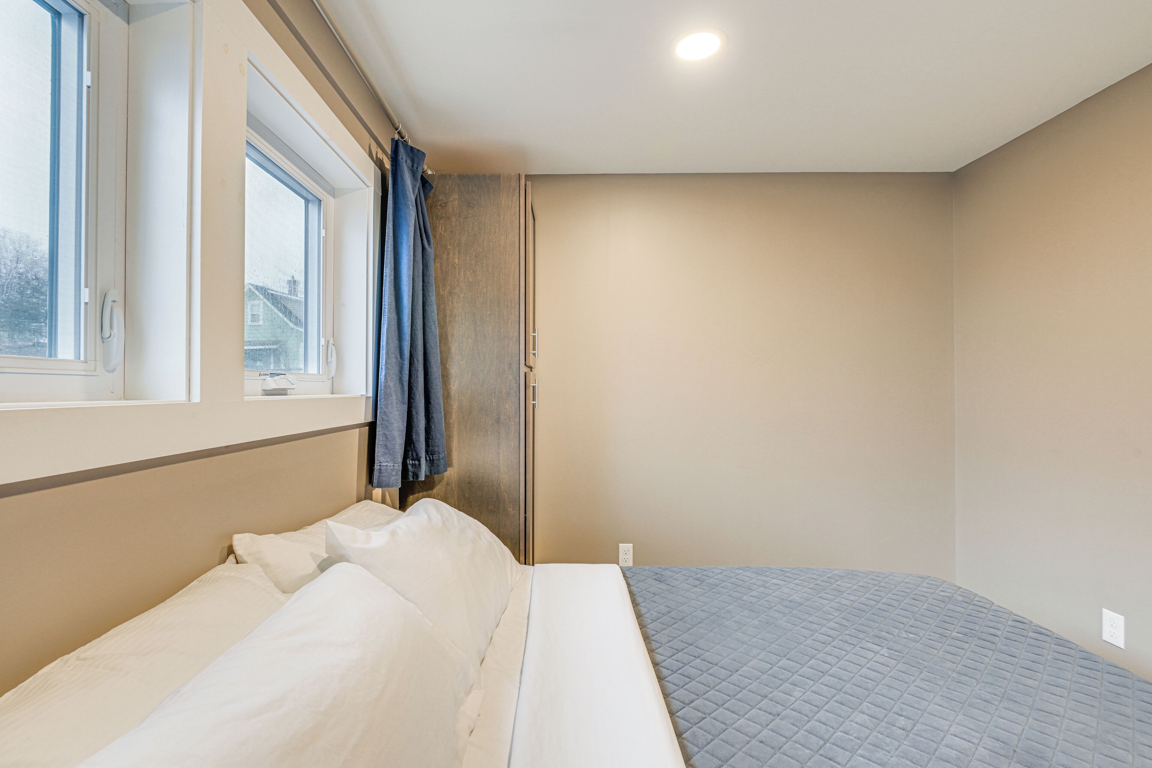 Un dormitorio con cama, ventana y puerta.