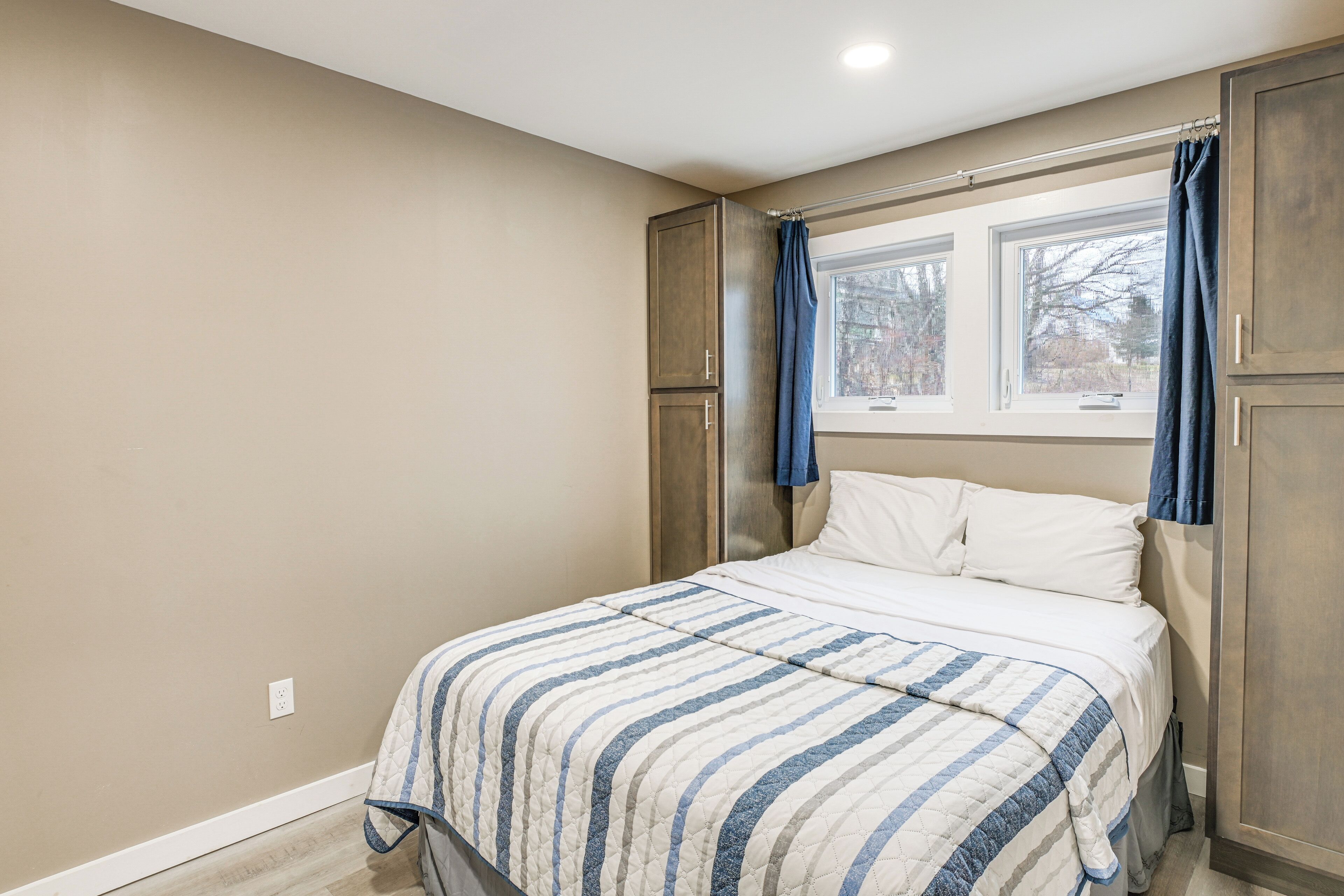 A bedroom with a bed, a window, and a wardrobe.