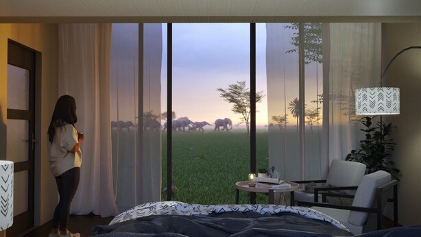 Una habitación con un ventanal grande, una cama, una silla, una mesa con una vela y una lámpara.
