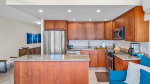Una cocina moderna con armarios de madera, electrodomésticos de acero inoxidable y una encimera de granito.
