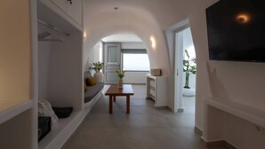 Un interior moderno con un sofá, una mesa y un televisor montado en la pared.