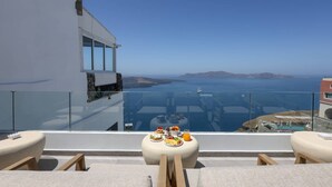Un balcón con mesa lista para el desayuno con vista al mar.