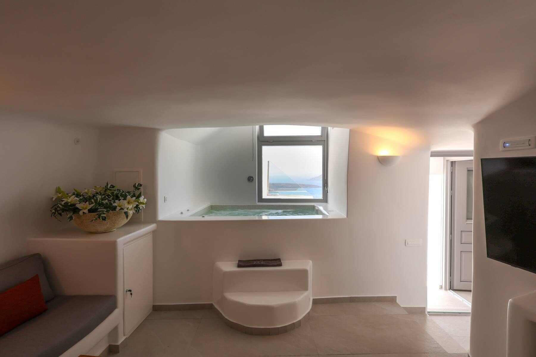 A modern bathroom with a bathtub, a small sink, and a window with a view.