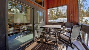 Un patio exterior con mobiliario de madera y puertas de cristal.