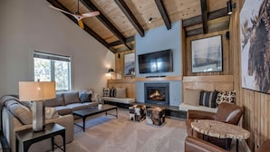 Una sala de estar acogedora con chimenea, asientos cómodos y un televisor.