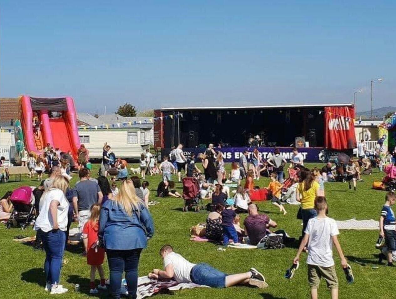 Un evento al aire libre concurrido, con escenario y carpas.