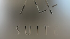 A logo with a stylized 'X' and a dash, followed by the word 'SUITE' in capital letters.