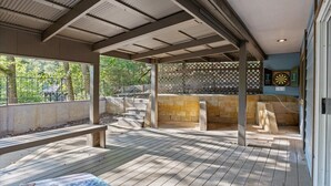 A covered outdoor area with a wooden deck, a bench, and a dartboard. - Cox Riverside Retreat - 32 miles to Springfield (Buffalo)