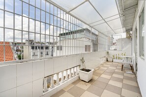 A spacious balcony with a checkered floor, white railings, and potted plants. - La Casona Boutique Hotel (Ho Chi Minh City)