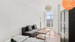 Een moderne woonkamer met een bank, een salontafel en uitzicht op de stad.