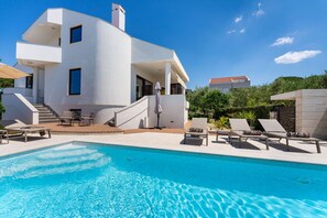 A modern two-story house with a swimming pool, outdoor seating, and a staircase leading to the upper floor. - Villa Bruna (Zadar)