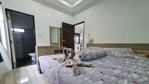A modern bedroom with a bed, a wardrobe, a mirror, and a bathroom visible through an open door. - D&A Paradise Villas (Koh Samui)
