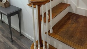 A wooden staircase with white balusters and a dark wooden floor. - The Modern Maine Retreat (Oakland)