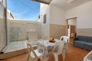 A small, open-plan living area with a dining table and chairs, a sofa, and a tiled floor. - 3766 Appartamento Ilde by Barbarhouse (Porto Cesareo)