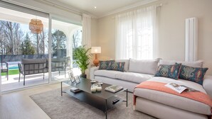 Un salon moderne avec un canapé, une table basse et une vue sur l’extérieur.