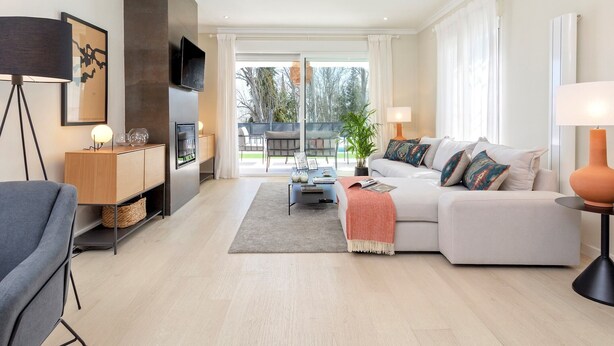 Un salon moderne avec un canapé, une table basse et un téléviseur fixé au mur.