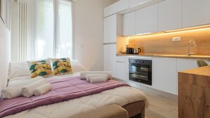 A modern bedroom with a bed, pillows, and a bedside table.
