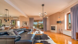 A spacious living room with a leather sofa, a coffee table, and a fireplace.