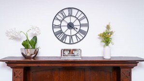 A wooden cabinet with a clock, two potted plants, and a small decorative item on top. - British Character in Golders Green. ground floor. 20min to oxford st. (London)