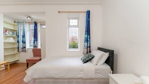 A bedroom with a bed, a chair, a desk, and a window with curtains. - British Character in Golders Green. ground floor. 20min to oxford st. (London)