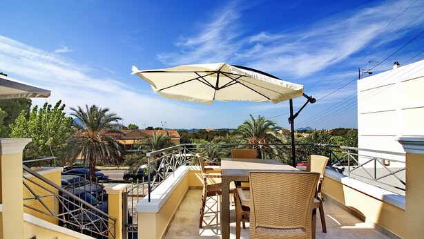A terrace with outdoor furniture, a table, and an umbrella. - Garitsa Gem Suite (Corfu)