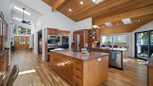 A spacious kitchen with wooden cabinets, a large island, and a modern design. - Rivers Edge Retreat, Luxury Waterfront Estate, Private Dock, Fire pit, Swimming (Post Falls)