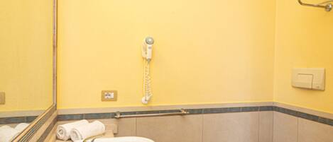 A bathroom with a sink, toilet, and mirror.