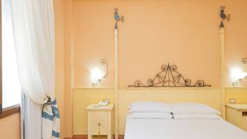 Une chambre à coucher avec un lit, une table de chevet, une lampe et une fenêtre avec des rideaux.