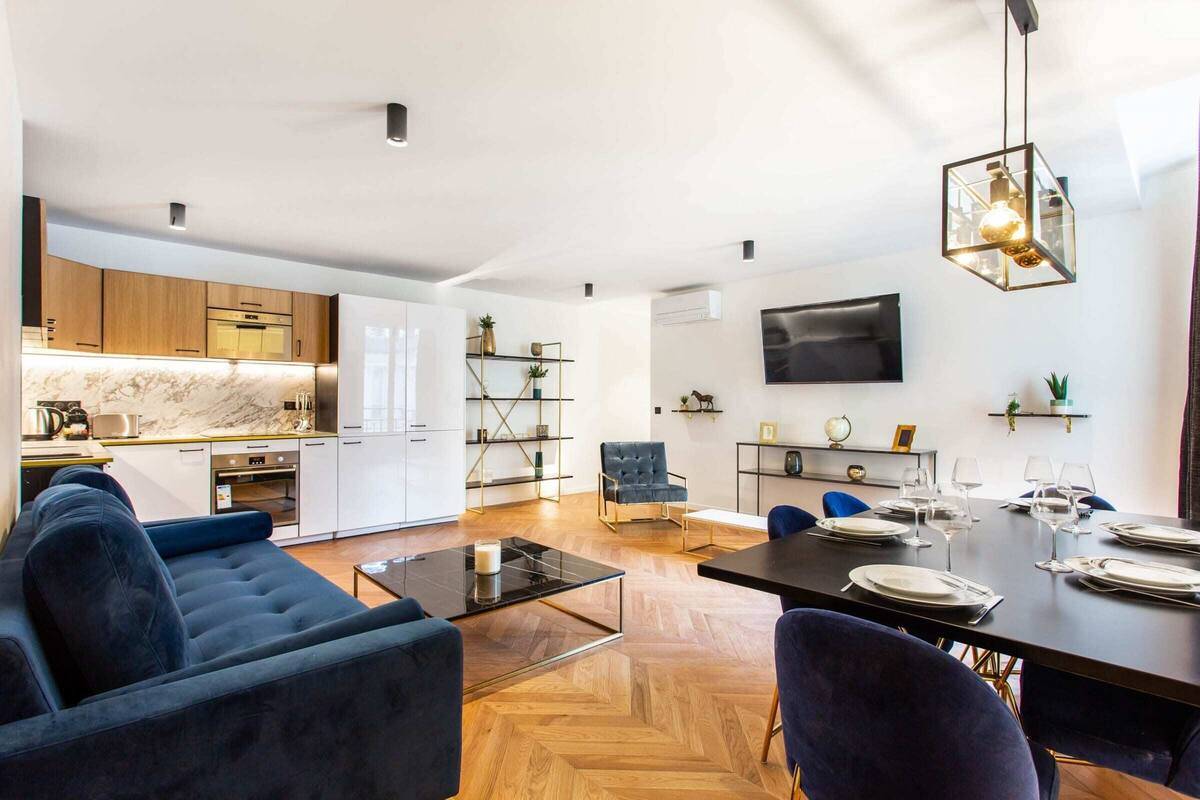 Um espaço de estar moderno com cozinha, sala de jantar e área de estar.