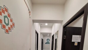 A hallway with white walls, marble flooring, and doors on both sides. - Armena Hostel (Yerevan)